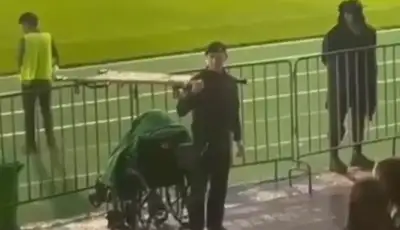 Желіде футбол матчының көрерменін жаңбырдан бүркеп тұрған полицейдің видеосы тарады